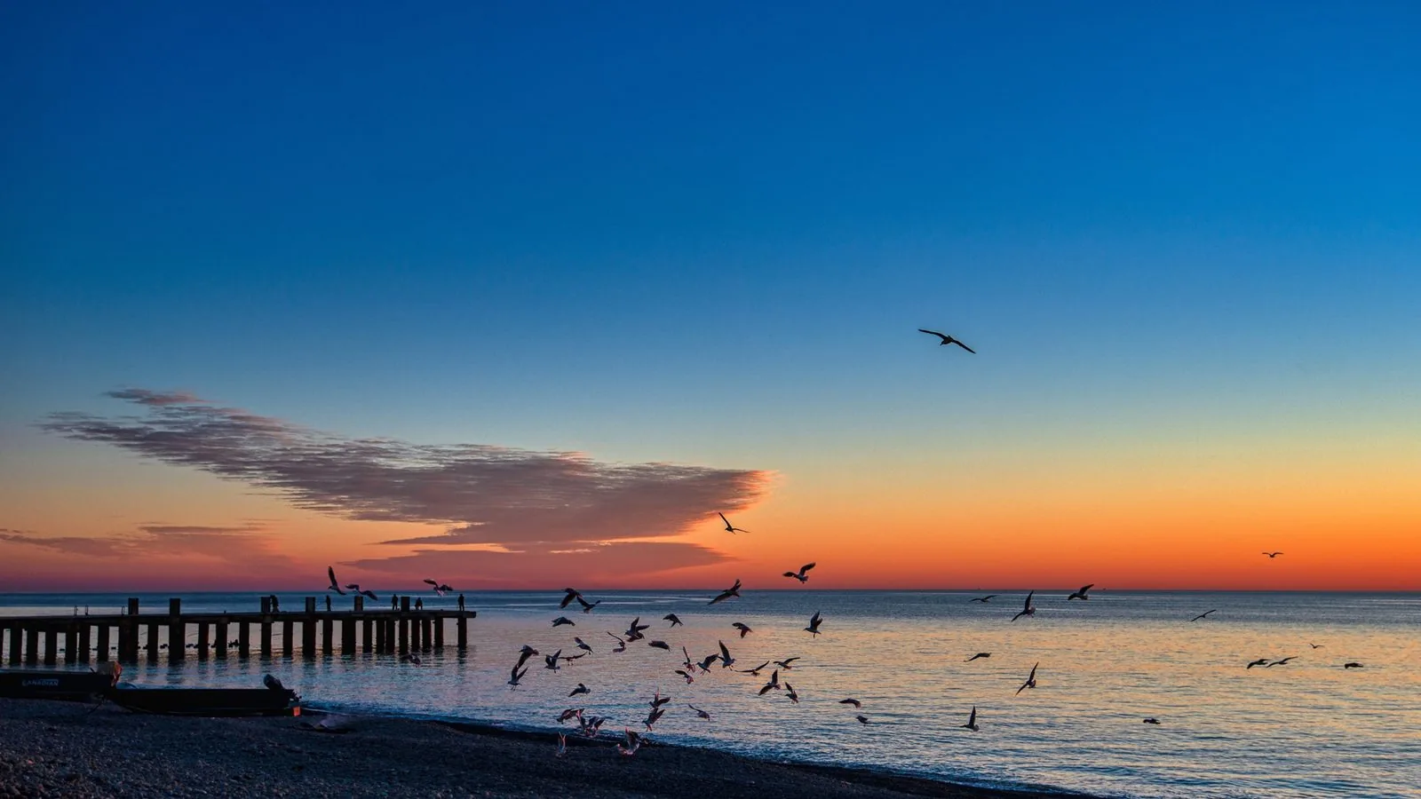 Il lungomare di Trebisacce al tramonto, con il pontile sul mare e i gabbiani in volo